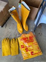 Boots, bagged rainsuit, gloves displayed on floor