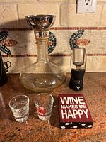 Whole lot showing decanter, funnel, Vinturi aerator, two shot glasses, and sign
