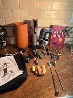 Group shot of all wine accessories, tools, chiller and book on countertop