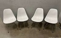 Front view of all four white Eiffel chairs aligned