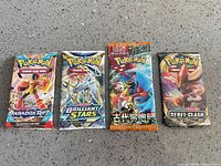 All four sealed Pokémon booster packs side by side
