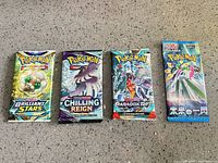 Group shot of four sealed Pokemon booster packs