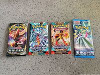 All four sealed booster packs side by side