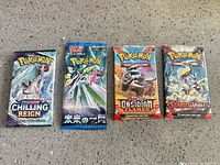 Group shot of four sealed Pokemon booster packs