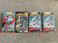 All four sealed Pokémon booster packs laid out