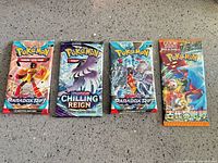 Front view of four sealed Pokemon booster packs in a row
