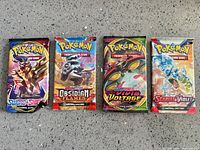 Front view of four sealed Pokemon booster packs