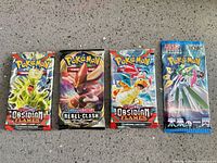Front view of four sealed Pokémon booster packs showing set names and artwork