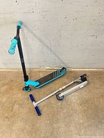 Both scooters displayed; Razor folded, stunt scooter upright
