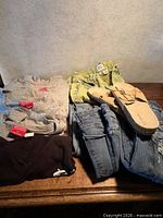 Group shot of all folded clothing and sandals on surface