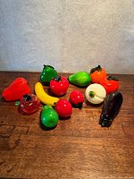 Group view of all glass fruit figurines on wooden surface