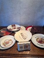 Overview showing multiple commemorative plates, open-book keepsake and praying hands plaque