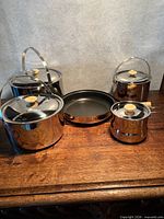 Full set showing three lidded pots, small lidded saucepan and frying pan