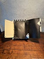 Stand holding binder pages open showing ring mechanism and page corners