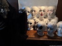 Group of foam heads with witch figure at side