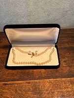 Necklace and earrings displayed in open velvet box