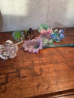 All six glass flower sculptures grouped on wooden surface