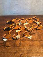 Group of twelve scroll-shaped wall hooks with tags