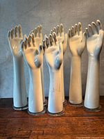 Front view of eight porcelain mannequin hands standing on bases