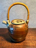 Full view of teapot showing body, spout, bamboo handle
