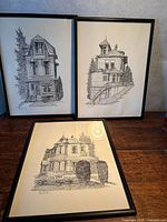 Three framed architectural drawings on tabletop