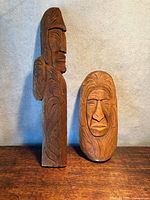 Both wood carvings side by side on tabletop