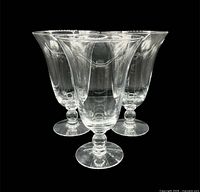 Front view of three clear hand-blown pedestal water goblets