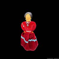 Front view of Navajo cloth doll in red velvet dress