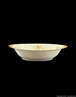 Side profile of oval porcelain bowl showing exterior shape and rim decoration