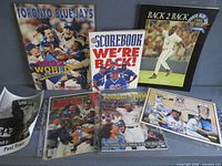All magazines, scorebook, postcards and autographed photo laid out to show covers and fronts