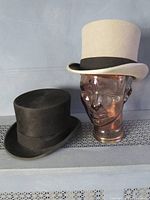 Black and gray Christys' London top hats side by side