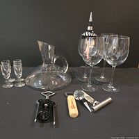 Full lot showing decanter, stemware, and bar tools on dark background