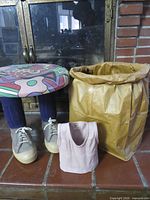 Overall view of stool, paper bag sculpture and doll vest
