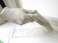 Overall view of plaster hand sculpture on acrylic base