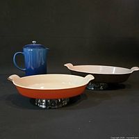 Group view of two oval gratin dishes and blue pitcher