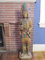Full view of carved wood totem statue standing on base