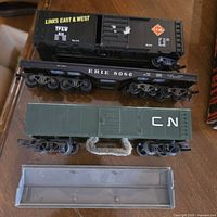 Overview of black TP&W boxcar, Erie underframe, green CN boxcar, and gray roof piece