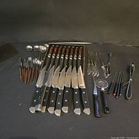 Full layout of 29-piece cutlery lot on black background