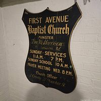 Full front view of First Avenue Baptist Church wood sign against wall