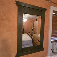 Front view of rectangular wood-framed mirror hung on wall