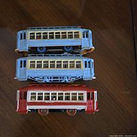 Three stacked trolley cars showing sides and colors