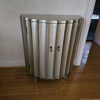 Full view of cabinet closed showing demi-lune shape and silver finish