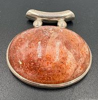 Front view of sterling silver pendant with sunstone cabochon