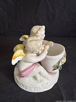Front view of porcelain figurine with two cherubs and dish