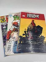 Front view showing Hellboy, Venom and third comic in plastic sleeve