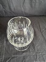 Side view of cut crystal brandy snifter showing bowl, cuts, and foot