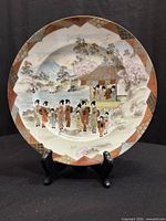 Front view of eggshell porcelain Satsuma plate on stand