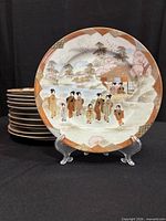 Front view showing painted design and stack of remaining plates