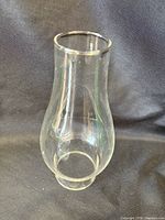 Clear glass lamp chimney standing upright