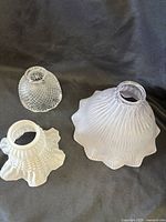 Group view of three glass lamp shades showing sizes and patterns
